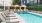 Apartments In Downtown Los Angeles - Gated Pool With Lounge Chairs, Umbrellas, And Tables.